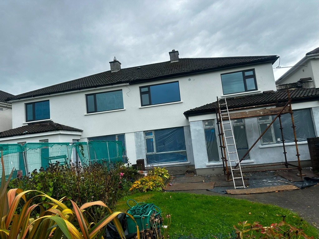 House under insulation construction with scaffolding and window protective covers